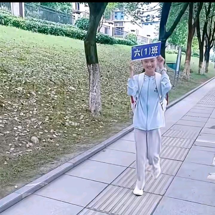 举班牌的小姑娘